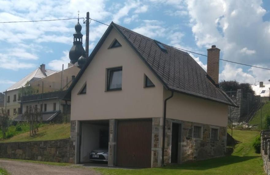 uma casa branca com um telhado preto em Chaloupka v Branne em Branná