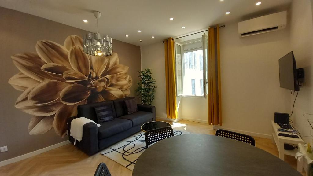un salon avec une table et une grande fleur sur le mur dans l'établissement Lovely apartment heart of Cannes, à Cannes