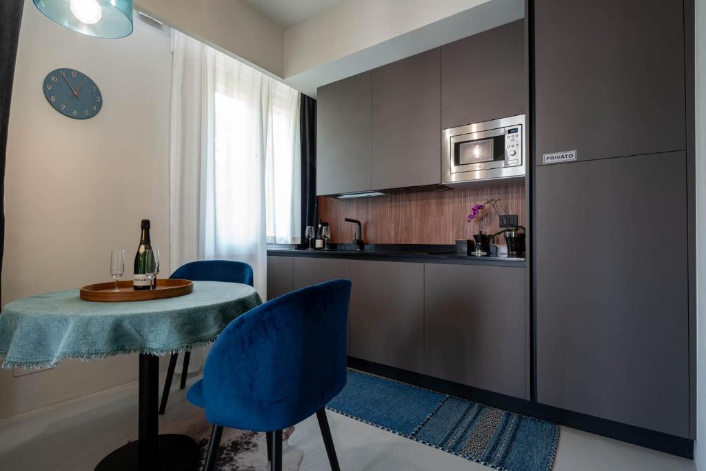 una pequeña cocina con mesa y sillas azules en Officine Cavour - Appartamenti la Quercia, en Padua
