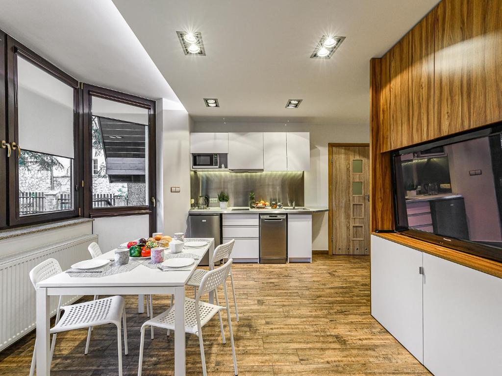 a kitchen and dining room with a table and chairs at VisitZakopane - White Valley Apartment in Zakopane