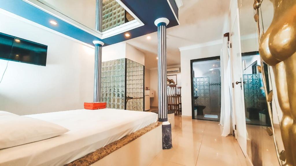 um quarto com uma cama branca e uma janela em Shopping Motel em Castanhal