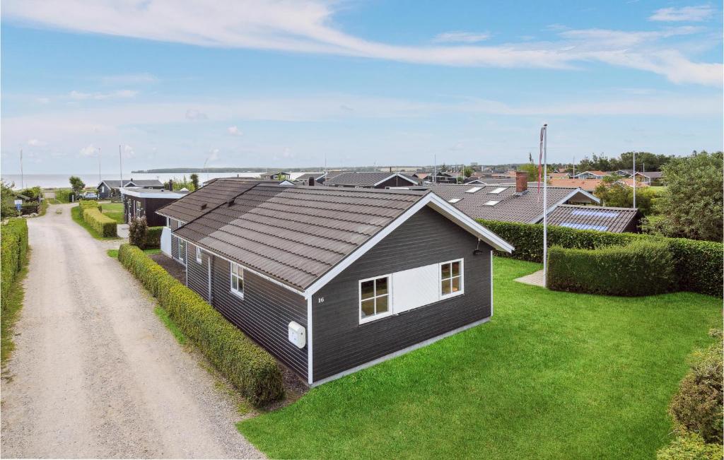 een zwart-wit huis aan de kant van een onverharde weg bij 3 Bedroom Awesome Home In Juelsminde in Sønderby