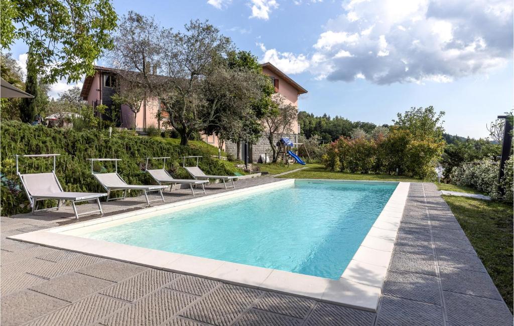una piscina con sillas y una casa en Awesome Home In Fivizzano With Kitchen, en Fivizzano