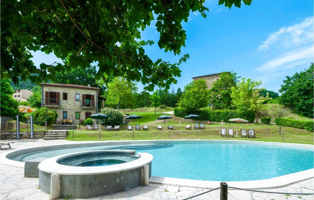 una piscina in un cortile con sedie e ombrelloni di Valguerriera - Sorgo ad Apecchio