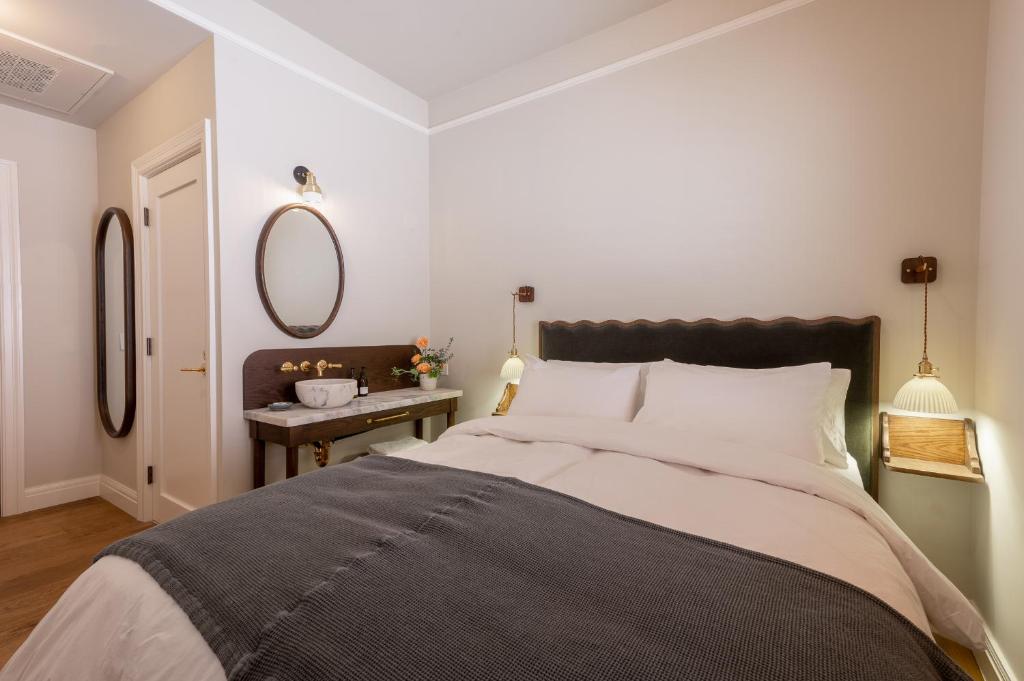 Un dormitorio con una cama grande y un espejo. en Gjelina Hotel, en Los Ángeles
