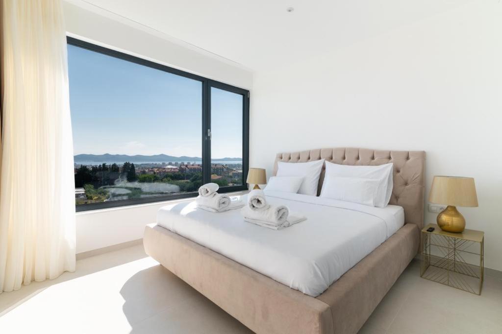 a bedroom with a large bed with a large window at Villa Aurum in Zadar