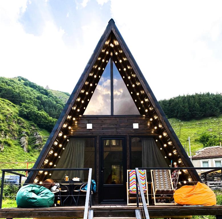 una casa con un techo triangular con luces encendidas en Cottage Rest in kazbegi en Stepantsminda