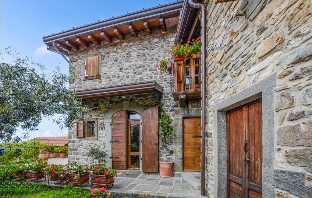 a stone house with a wooden door and flowers at 3 Bedroom Cozy Home In Comano in Comano