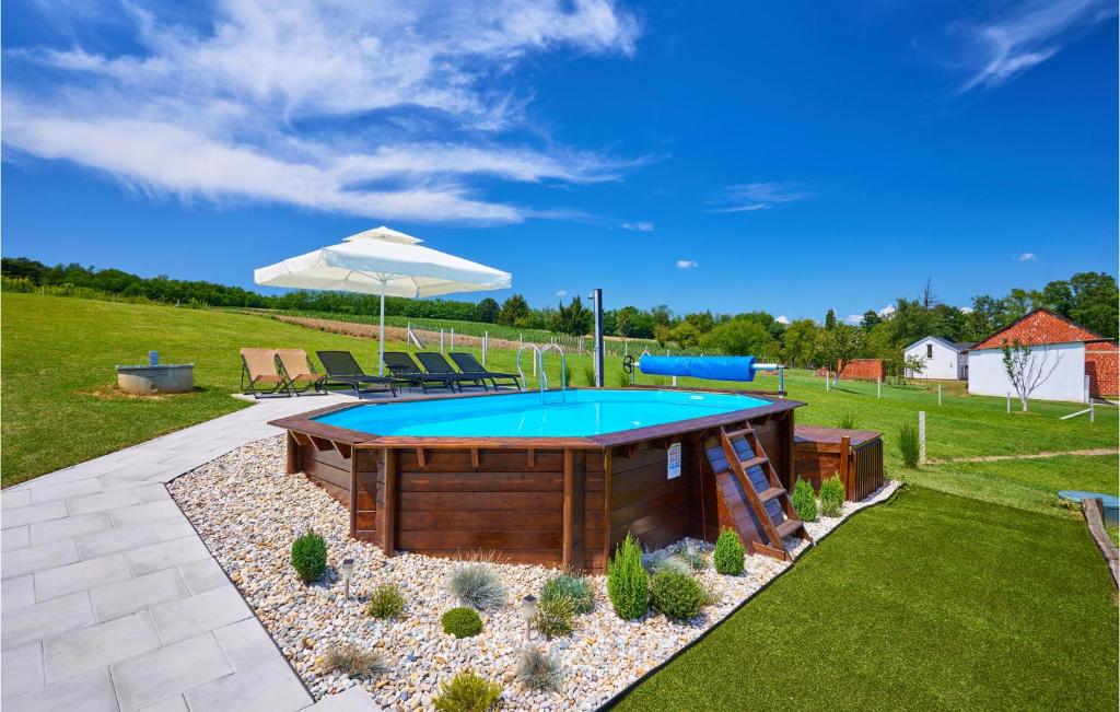 a pool with a table and an umbrella in a yard at Amazing Home In Banovo With Heated Swimming Pool in Vrbovec