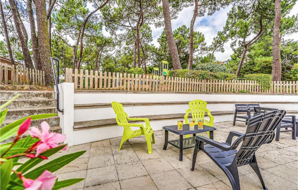 a patio with chairs and a table with candles on it at 2 Bedroom Beautiful Home In La Faute-sur-mer in La Faute-sur-Mer