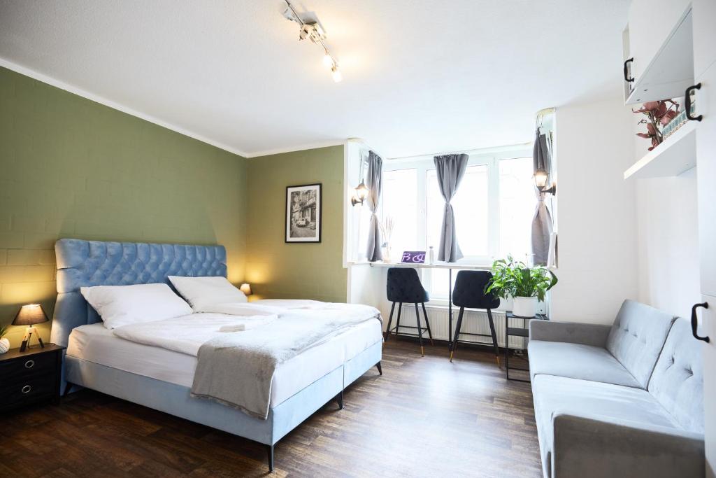 a bedroom with a bed and a couch at Stilvolles Ruhiges Studio - PARKPLATZ, WIFI, TV EM-APARTMENTS DEUTSCHLAND in Bielefeld