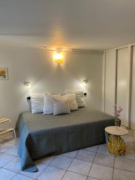 ein Schlafzimmer mit einem großen Bett mit einer Lampe an der Wand in der Unterkunft Beautiful studio + large terrace near the beaches. in Antibes