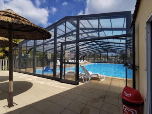 a large swimming pool with a glass wall around it at Mobile Home in Avrillé