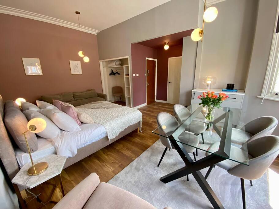 Studio for 3 near Regents Park n5 في لندن: غرفة معيشة مع أريكة وطاولة زجاجية