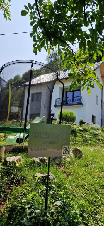 ein Schild im Gras vor einem Haus in der Unterkunft Apartment Stella Danica in Čatež ob Savi