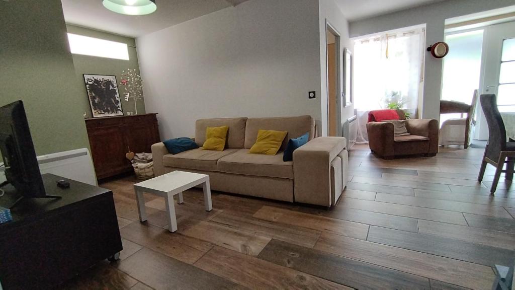 a living room with a couch and a tv at Ruthene Etape Appartement T3 in Rodez