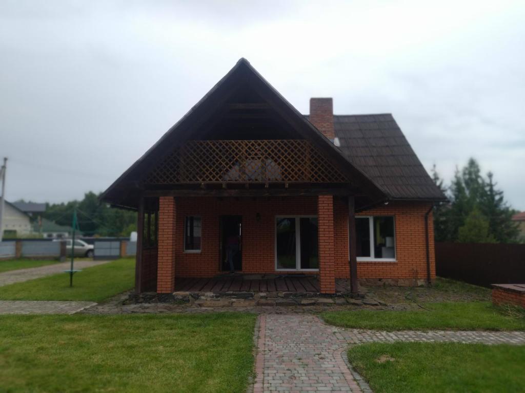 uma pequena casa de tijolos com um telhado preto em ГРАНД em Szack