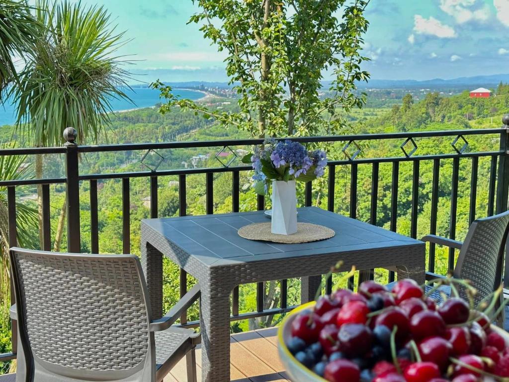 a table and chairs with a bowl of fruit on a balcony at Magical space Tsikhisdziri in Tsikhisdziri