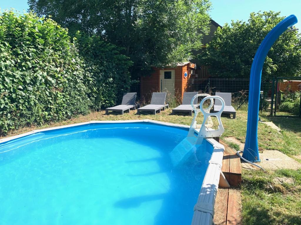 a swimming pool with two chairs and a gazebo at Les Maitres Sonneurs in Huriel