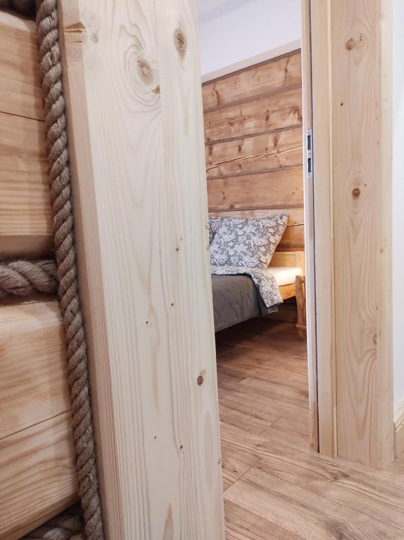 a log cabin with a bed in a room at Apartamenty Przy Rynku Szaflary in Szaflary