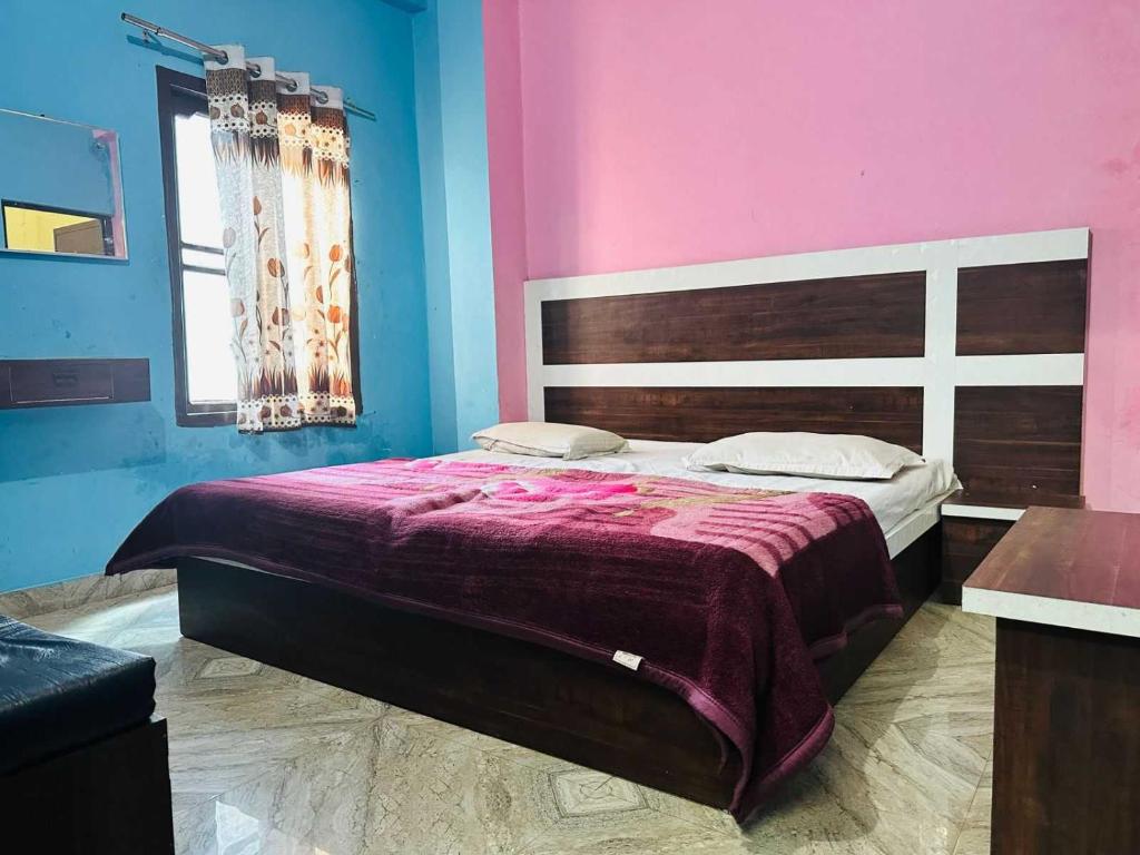 a bedroom with a bed with a pink and blue wall at OYO Hotel Verma Residency in Katra