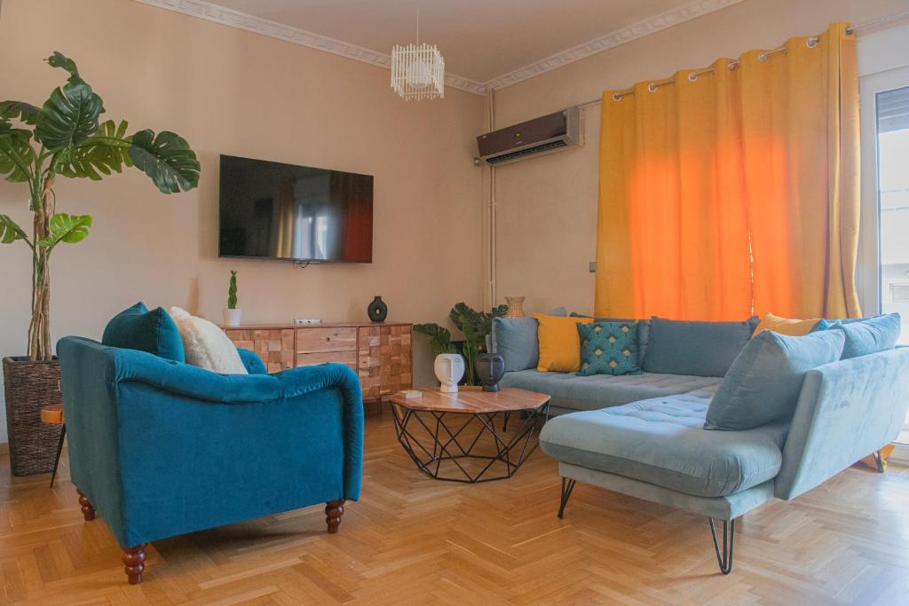 a living room with two blue chairs and a couch at Urban Oasis, Stylish Short Stay Apartment in Piraeus Center in Piraeus