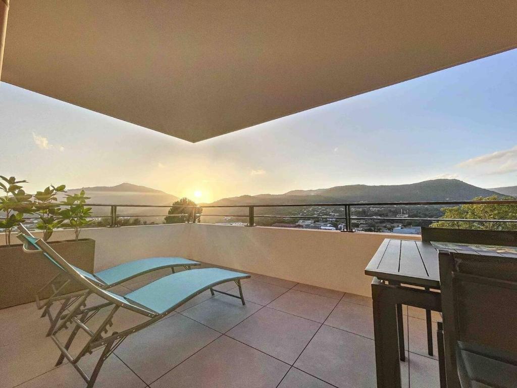 a balcony with a chair and a view of the mountains at Appartement central avec très jolie vue in Ajaccio