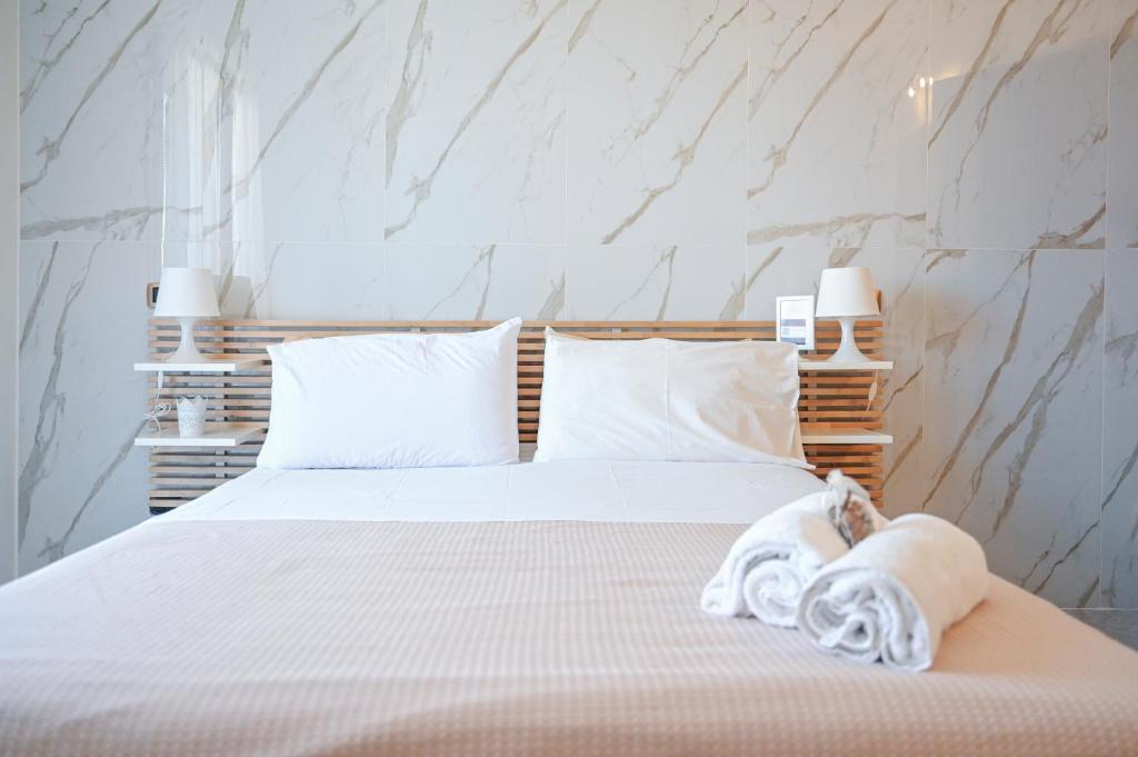 a bedroom with a white bed with towels on it at Il Porticciolo in Scilla