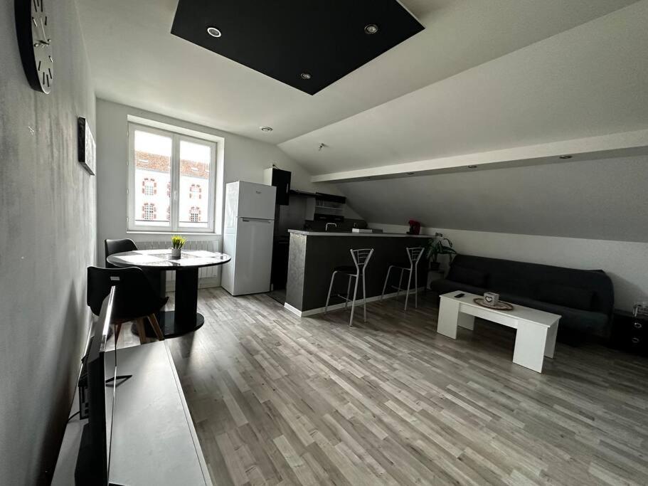 een woonkamer met een bank en een tafel bij Très beau studio in Thierville-sur-Meuse