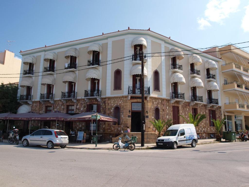 a large white building with cars parked in front of it at Istiaia Hotel Spa in Loutra Edipsou