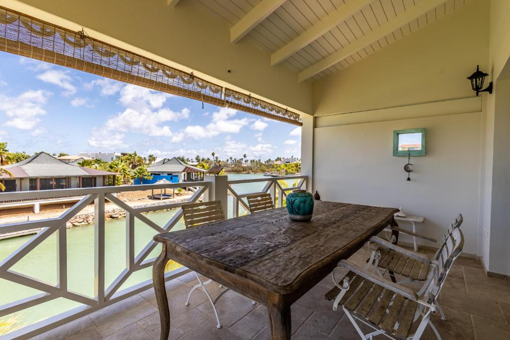 une terrasse couverte avec une table et des chaises en bois sur un balcon dans l'établissement Loft Bahia Blue, à Kralendijk
