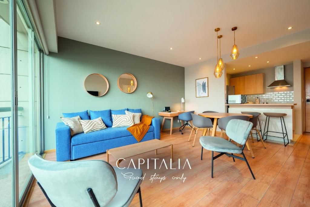 a living room with a blue couch and a table at Capitalia - Apartments - Santa Fe in Mexico City