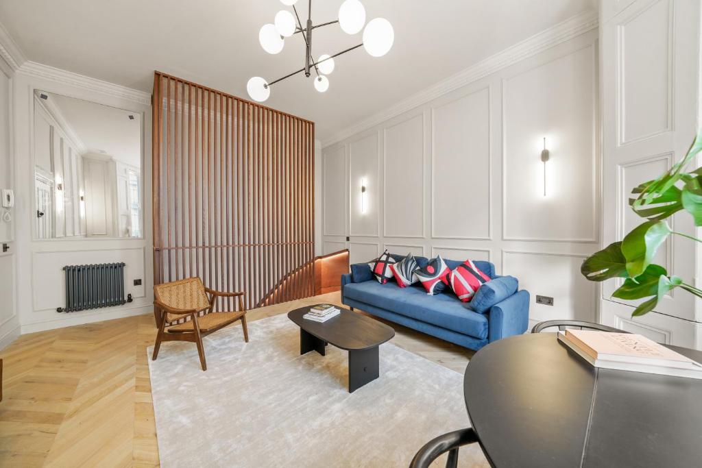 sala de estar con sofá azul y mesa en Reside Global - 2 Bed Flat Walking Distance From Harrods, en Londres