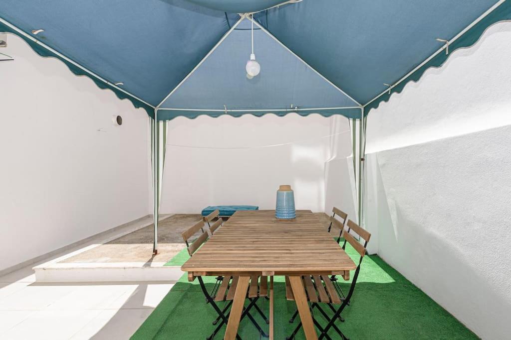 a tent with a wooden table and chairs in a room at Casa de Moscavide 19 in Lisbon