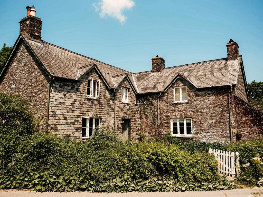 duży kamienny dom z dachem w obiekcie The Farmhouse Hideaway w mieście Calstock