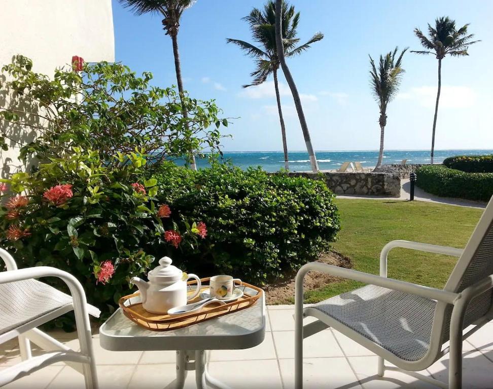 West Bay的住宿－Beach Living at Villas Pappagallo Beachfront 22，海滩庭院的桌子上放着一盘茶