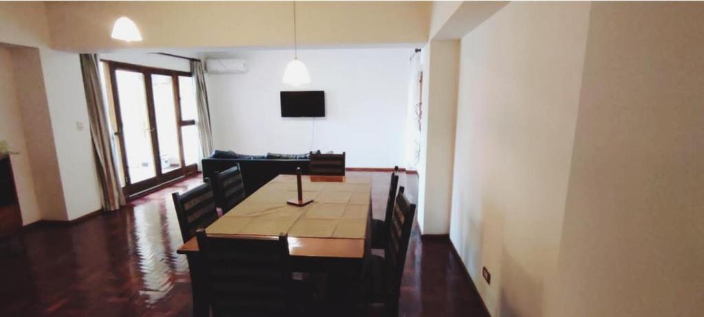 a dining room with a table with chairs and a television at Departamento calle España in Mendoza