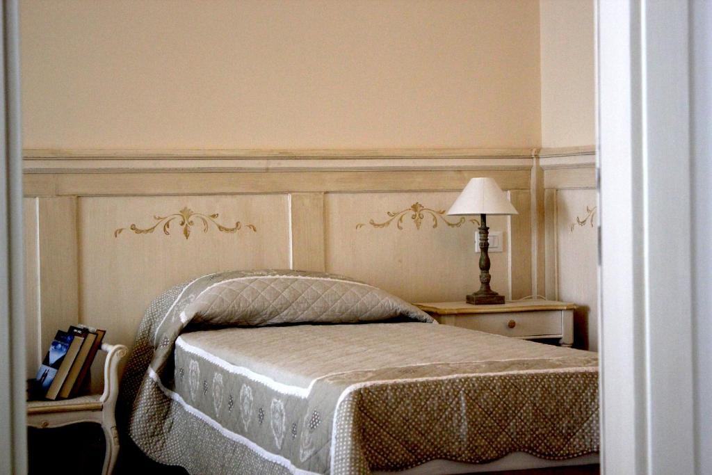 a bedroom with a bed and a table with a lamp at Casa Camilla City in Padova