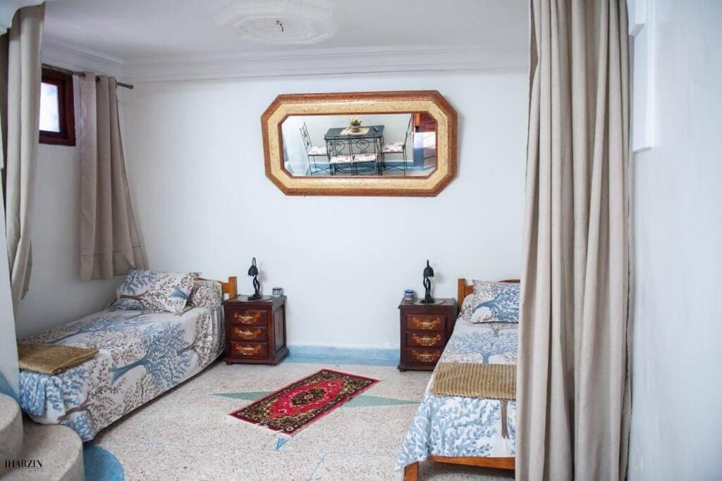 Chez laasri في شفشاون: غرفة معيشة مع أريكة ومرآة