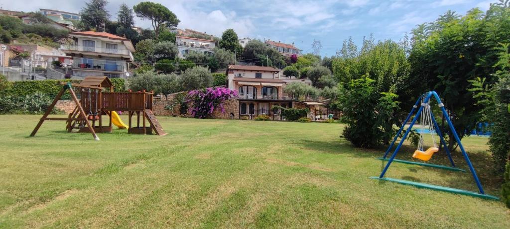un parco giochi in un cortile con una casa sullo sfondo di Agriturismo PeterPan a Pietra Ligure