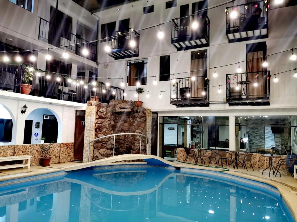 a large swimming pool in a building with lights at Hotel San Isidro in Pisco