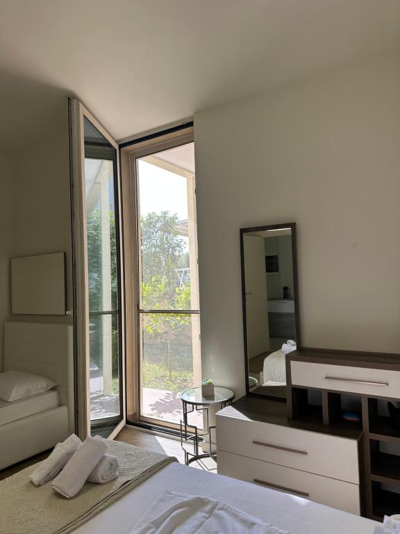 1 dormitorio con cama y espejo grande en Green Coast Resort Vila 143B, en Dhërmi