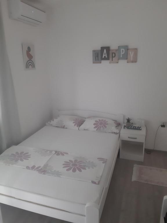 uma cama num quarto com um sinal de felicidade em Apartman Sema em Donji Štoj