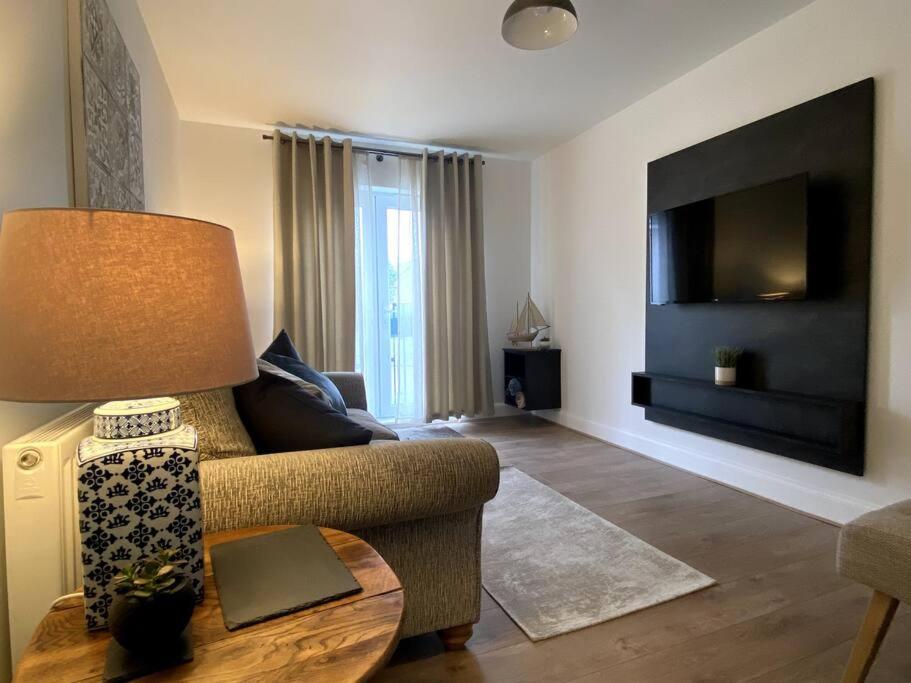 uma sala de estar com um sofá e uma mesa com um candeeiro em Luxury 2 Bed Apartment - Near to Sherwood Forest em Ollerton