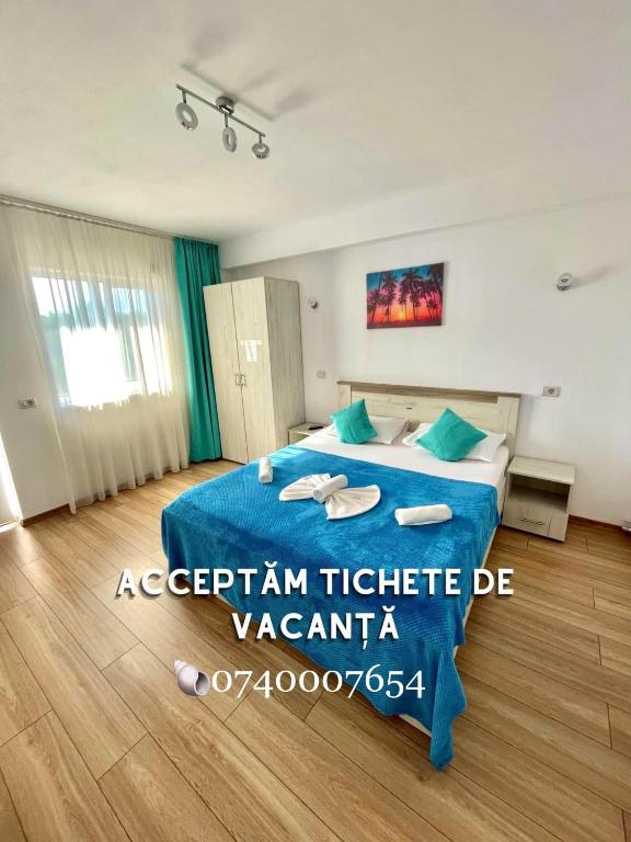 a bedroom with a blue bed in a room at Vila Cochilia Costinesti ULTRACENTRAL 3 stele in Costinesti