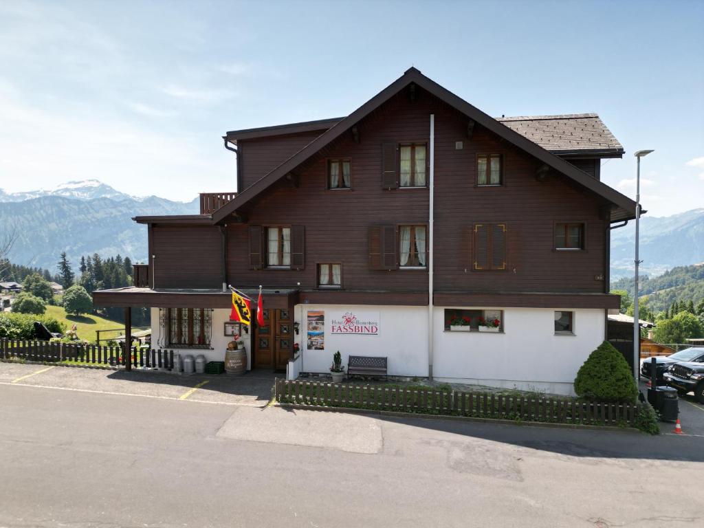 a large wooden building with a sign in front of it at Hotel Fassbind Beausite in Beatenberg