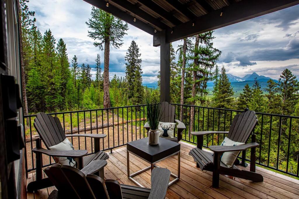a porch with chairs and a table on a balcony at Thunderbird Ridge - Cabin 1 - Summit in Polebridge