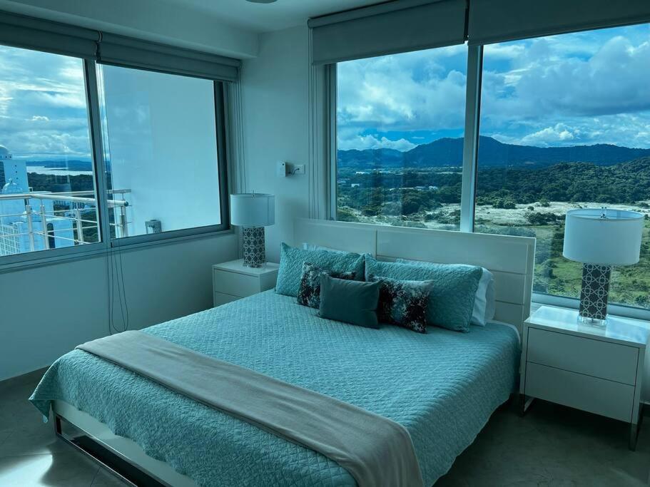 um quarto com uma cama grande e janelas grandes em 22M Spectacular Penthouse New Design Oceanview em ArraijÃ¡n