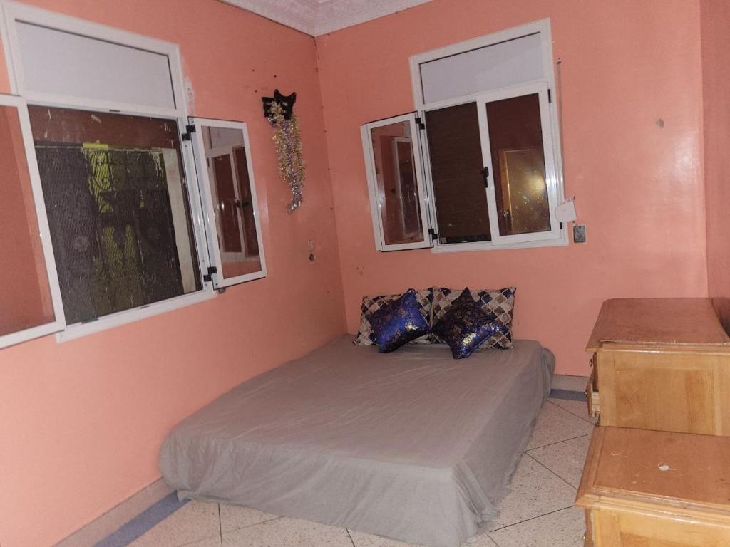 een slaapkamer met een bed en 2 ramen bij khenifra in Khenifra