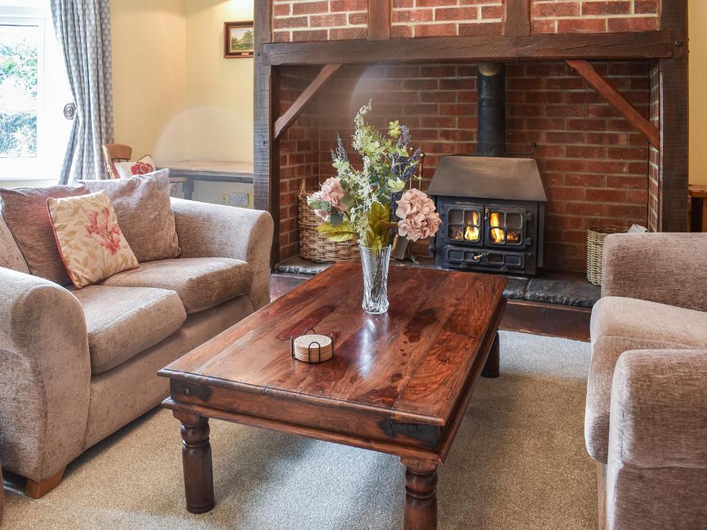 a living room with a table and a fireplace at Swallows Way in Briston